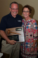 Outgoing AAPSM President David Davidson, DPM is presented his presidential plaque by incoming president Karen Langone, DPM for years of dedicated service to the Academy