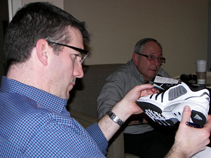Rob Conenello evaluates an athletic shoe as Dr. Jeff Carrel looks on in the background.