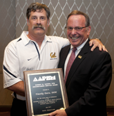 Tim Dutra, DPM (left) accepts Robert Barnes Distinguished Service Award from AAPSM Past President David Davidson, DPM